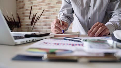 el hombre de negocios en la oficina escribe notas en el cuaderno