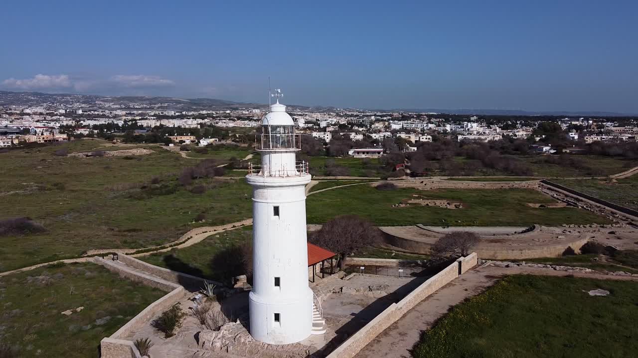 impresionantes imágenes de drones giratorios que rodean un faro blanco en chipre, grecia con la ciudad al fondo