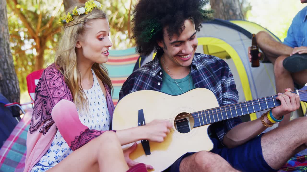 Couple playing guitar at music festival 4k