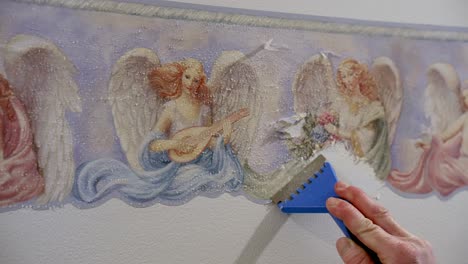 renovate by scraping old wallpaper from the surface with handy tool