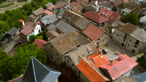 Aerial-view-of-church-roofs-and-rustic-stone-houses-in-Spanish-mountain-village