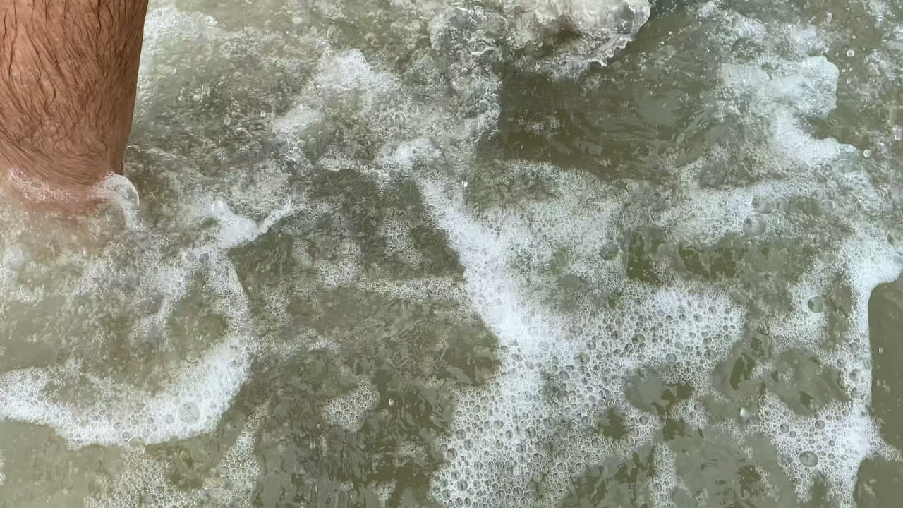 hombre caminando a través del huracán tormenta marea de agua, punto de vista de las piernas y los pies