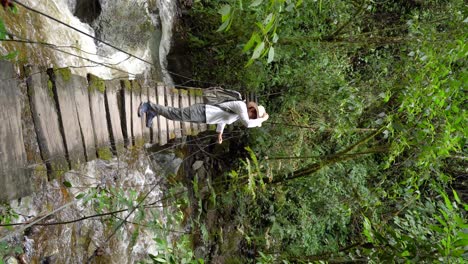 Woman-traveler-walking-on-footpath-above-river