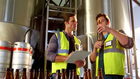 two brewers checking beer bottles 4k