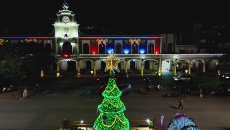 hermoso árbol de navidad coronado con una estrella brillante en la noche frente al ayuntamiento en ciudad guzman, jalisco, méxico