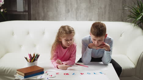 Ein-Paar-Kinder-Lernen-Am-Couchtisch-Ziffern-Mit-Karten