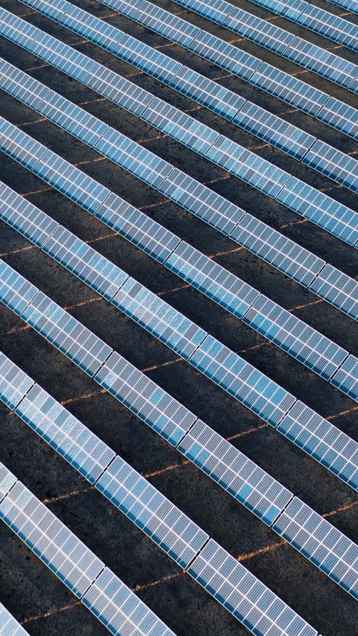 Aerial view of rows of solar panels in a field. Green energy landscape electrical power ecology innovation nature environment. Vertical video