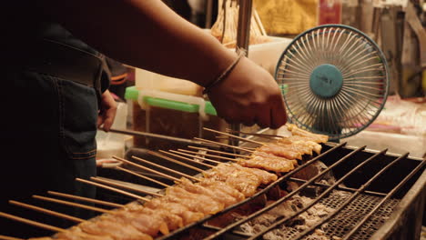 Satay-De-Pollo-A-La-Parrilla-Sobre-Carbón-Con-Condimentos-Comida-Callejera-Bangkok-Tailandia-Por-La-Noche