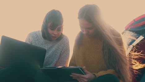 girl-tourists-with-tablet-and-laptop-in-camp-slow-motion