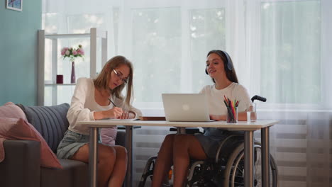 woman-with-disability-enjoys-music-while-focused-friend-writing