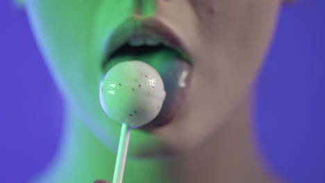 Close-up face caucasian sexy woman, sensually licking lollipop, studio shot