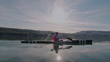 Hombre-En-Kayak-En-Un-Lago-Tranquilo-En-Suiza-Durante-La-Puesta-De-Sol