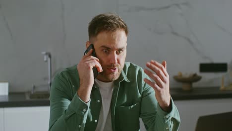 hombre hablando en un teléfono celular en la cocina