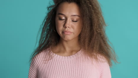 caucasian curly haired woman waving no in front of the camera.