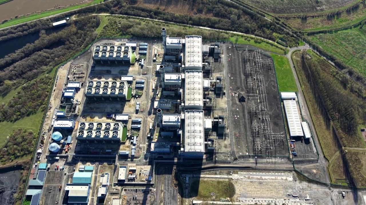 Ripresa aerea dall'alto di schiere di ventole di raffreddamento del modulo turbina a gas CCGT vicino alle torri di raffreddamento di West Burton