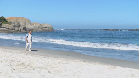 aged man walking along the beach