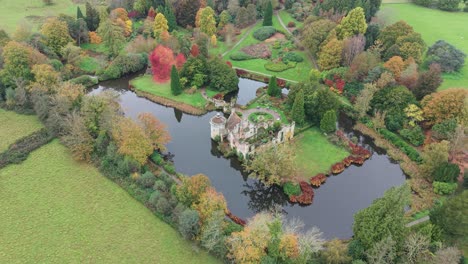 aerial view of an autumnal castle ruin surrounded by a lake