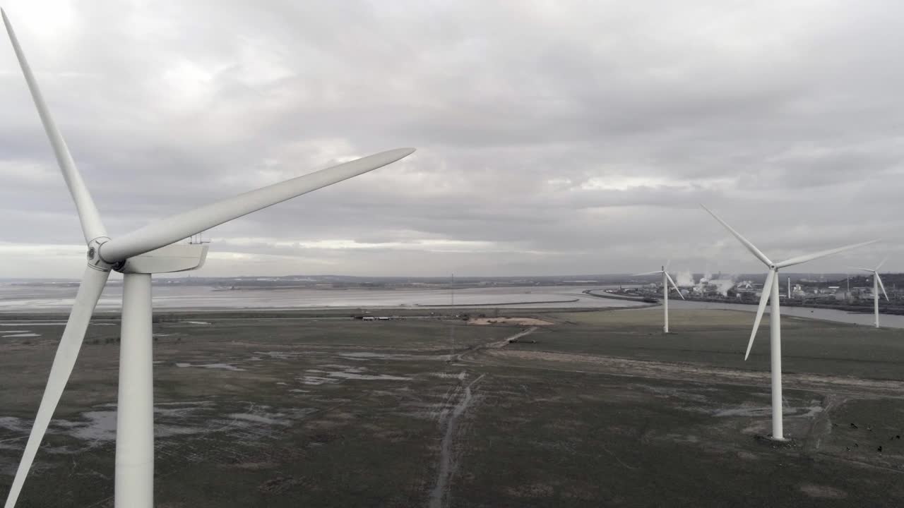 영국 농지에서 회전하는 지속 가능한 전기 풍력 터빈은 지나가는 블레이드를 밀어냅니다.