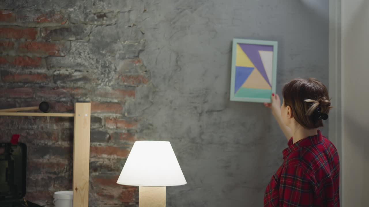 mujer busca un lugar para pintar en la pared de grange en la habitación