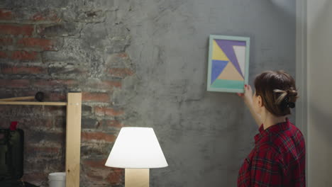 mujer busca un lugar para pintar en la pared de grange en la habitación
