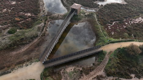 Antena-De-Establecimiento-De-Puentes-De-Madera-Camino-A-Pie-En-La-Costa-Brava,-España,-Círculo-Pan