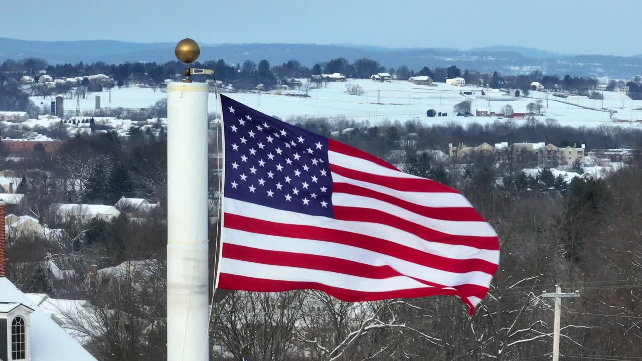 Bandiera americana che sventola davanti a un paesaggio invernale innevato in città
