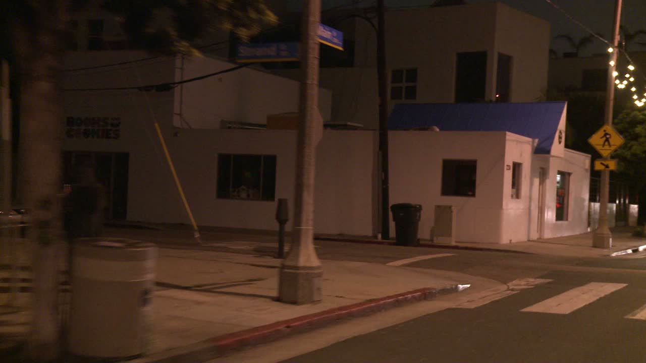 автомобиль едет по улице ночью в санта-монике, калифорния, как видно через заднее стекло под углом 3