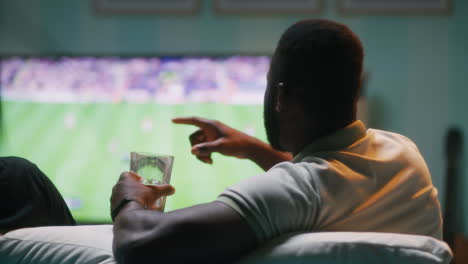man watching football game at home