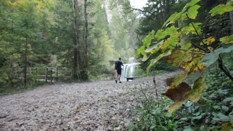 a man exploring martuljek waterfall during the day in gozd martljek in slovenia and the triglav national park