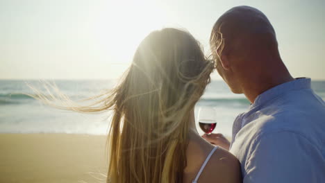 Pareja-Sosteniendo-Copas-De-Vino-En-La-Playa