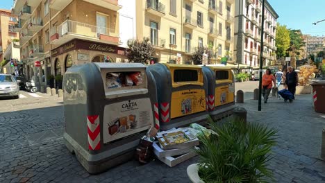 busy street with trash bins and pedestrians