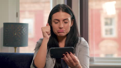 Una-Joven-Atractiva-Se-Sentó-En-El-Sofá-Viendo-Deportes-Por-Teléfono-Y-Su-Equipo-Pierde