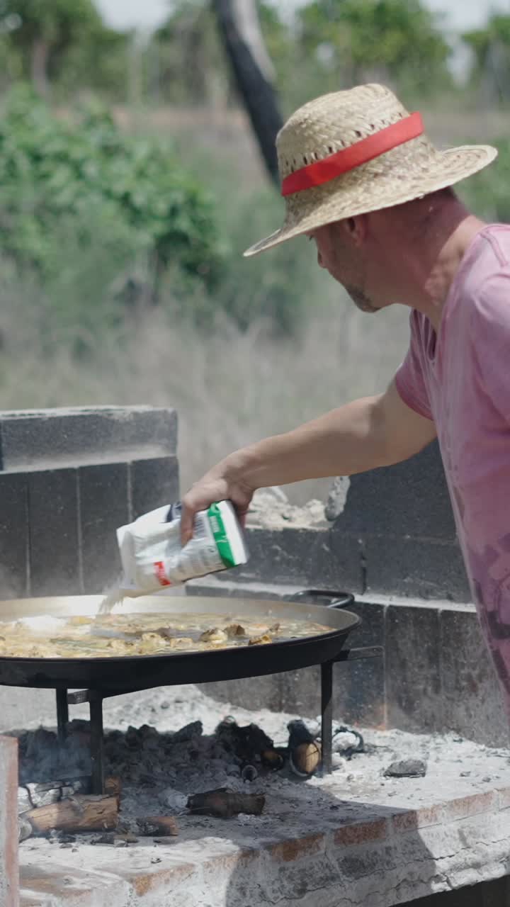 Man cooking paella outdoors