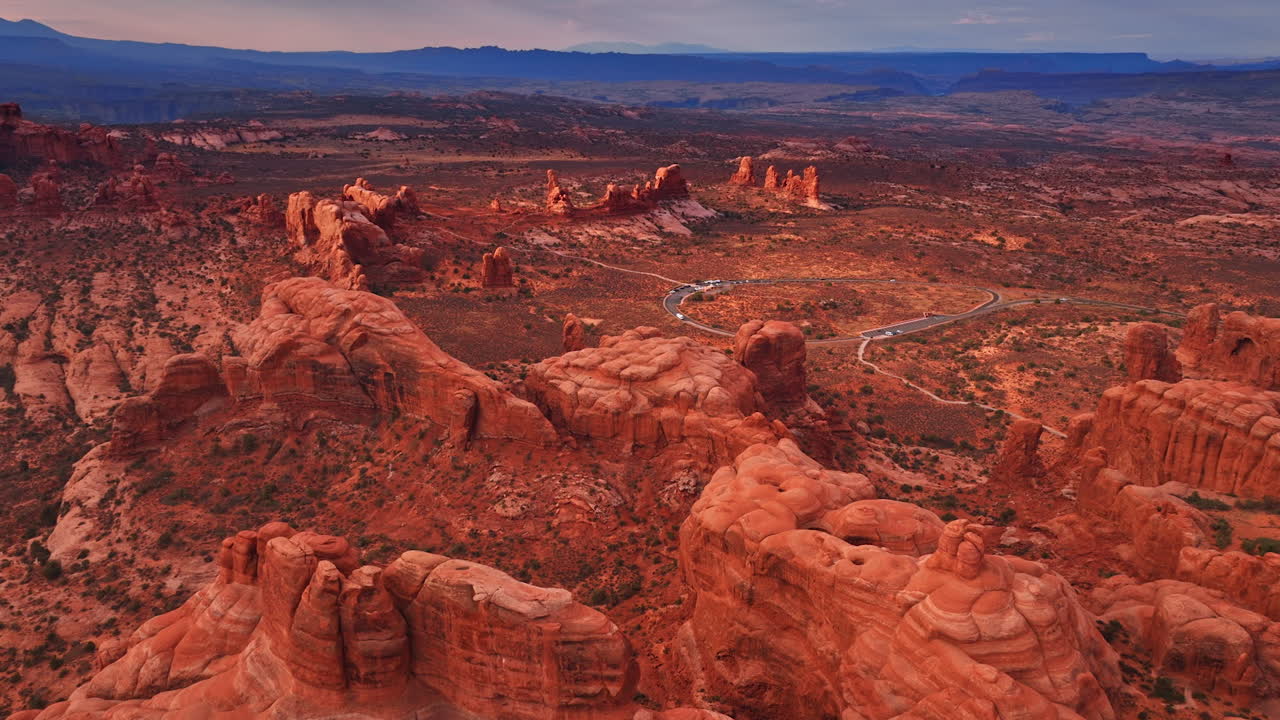 Avvicinamento all'ansa della strada che attraversa lo spettacolare deserto. Vista sulle incredibili rocce con cime arrotondate nell'Arches National Park, Utah, USA