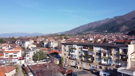 Drone-rising-over-the-town-of-Sopot-in-Plovdiv,-Bulgaria,-on-a-sunny-day