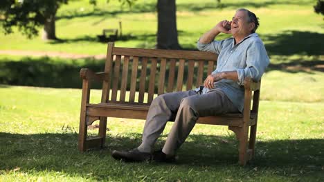 Old-man-talking-on-the-phone-on-a-bench