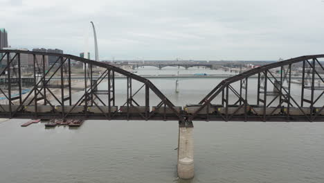 Toma-Estática-Aérea-Del-Tren-Y-El-Tráfico-Que-Se-Mueve-A-Través-De-Los-Puentes-Del-Río-Mississippi