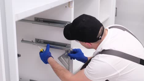 a professional master during the installation of kitchen furniture a professional master during the installation of kitchen furniture installation of modern highquality furniture accessories moving to a new apartment