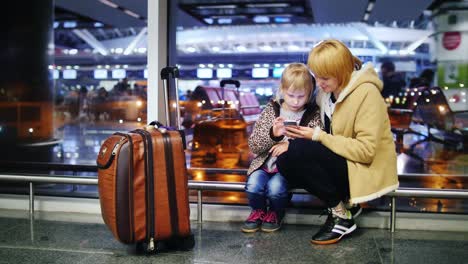 Mama-Und-Tochter-Gegen-Das-Fenster-Im-Flughafen