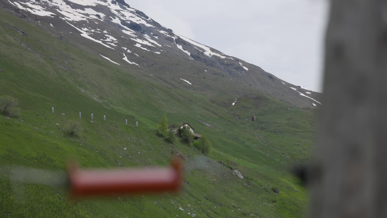 Truck left capturing the lush green landscapes of Mont Cenis, with snow-capped peaks in the distance