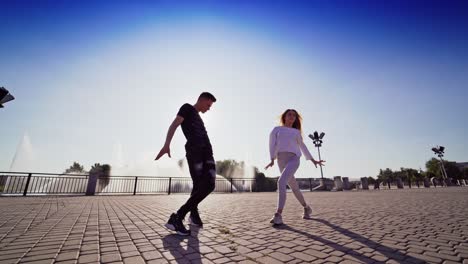 dancing couple in the city. outdoor view of young beautiful fashionable couple dancing in the street. street dance on the sunlight.