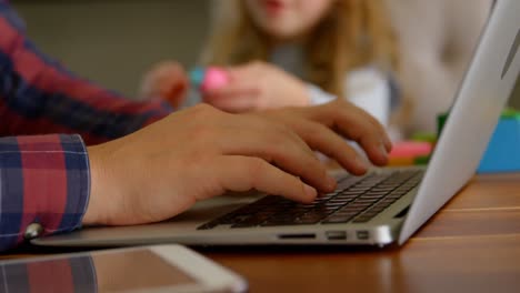 Father-using-laptop-while-daughter-playing-with-clay-in-living-room-4k