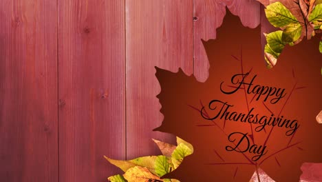 Happy-thanksgiving-day-text-over-autumn-maple-leaf-against-autumn-leaves-on-wooden-background