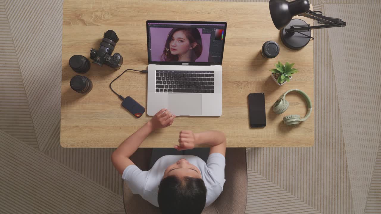 Top View Of Asian Woman Editor Yawning And Sleeping While Sitting In The Workspace Using A Laptop Next To The Camera Editing Photo Of A Woman At Home