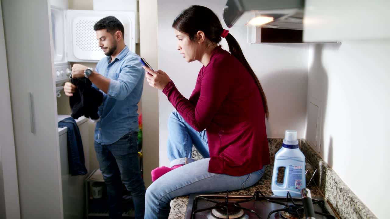 남자 와 여자 가 집안 일 을 하고 옷 을 고 있다