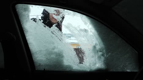 Schnee-Bedeckt-Autofenster,-Das-Im-Winter-Von-Einer-Frau-Geräumt-Wird