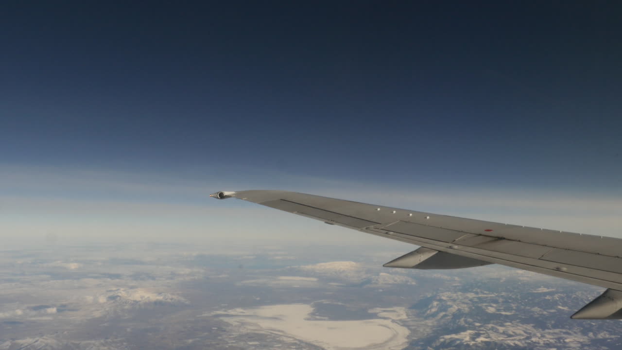 vista aérea de montañas cubiertas de nieve desde la ventana de un avión volador filmada en alta resolución de 4k
