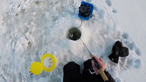 pescador de hielo pescando en una región nevada