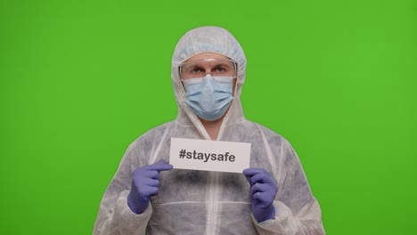 portrait of medical doctor in ppe suit with text inscription slogan on paper stay safe on chroma key