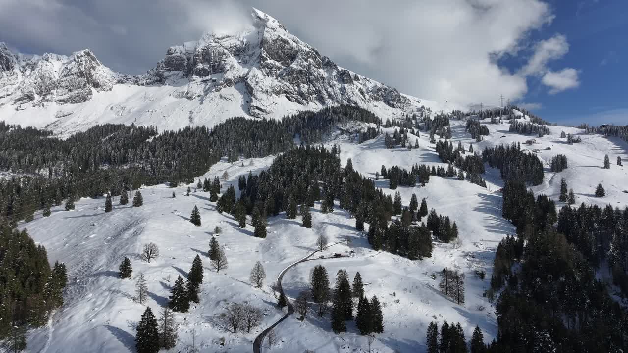dolly hacia adelante hacia la montaña alpina cubierta de nieve con árboles de hoja perenne esparcidos, ubicación de la estación de esquí